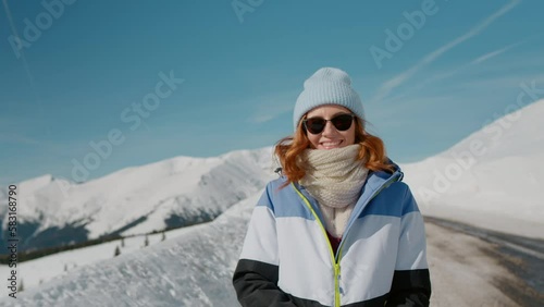 Lonely female trekker dressed jacket walking by snowy slope footage in mountains. Smiling young woman on vacation with lot of snow. Beauty in Nature concept video photo