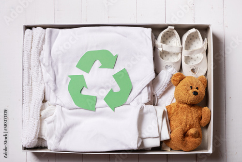 Children's clothes, shoes and toys in donation box. Second hand, clothing recycling, reuse concept photo