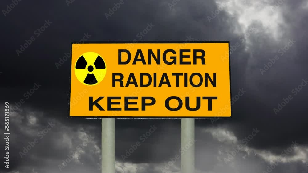 Radiation energy and radioactivity.. Zoom in to a simulated Radiation Keep Out road transport sign with time lapse dark clouds in the background. Radiation energy and radioactivity.. Zoom in to a simulated Radiation Keep Out road transport sign with time lapse dark clouds in the background.