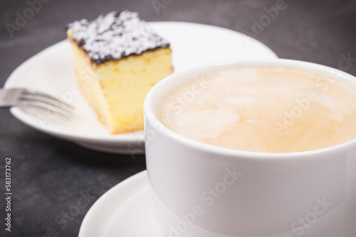 Cup of coffee with milk and fresh baked cheesecake. Delicious dessert