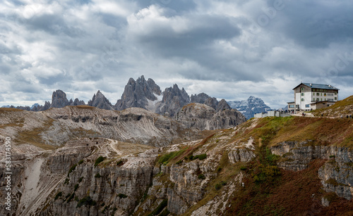 Panorama of mountains and hills in Dolomites with mountain hut
