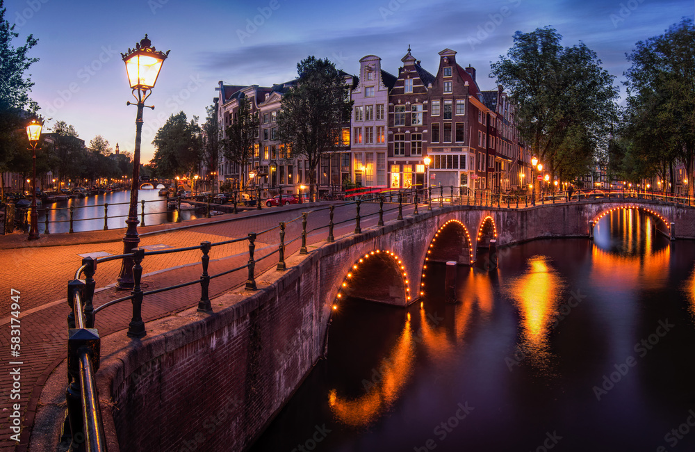 Night view of old houses and bridge in the streets of Amsterdam with streets lights