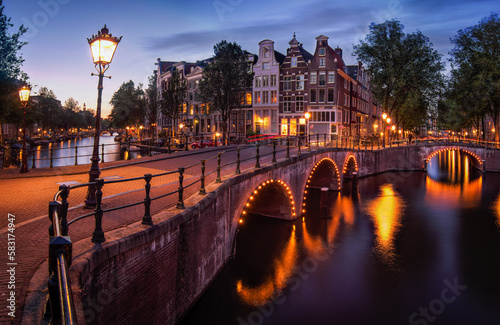 Night view of old houses and bridge in the streets of Amsterdam with streets lights