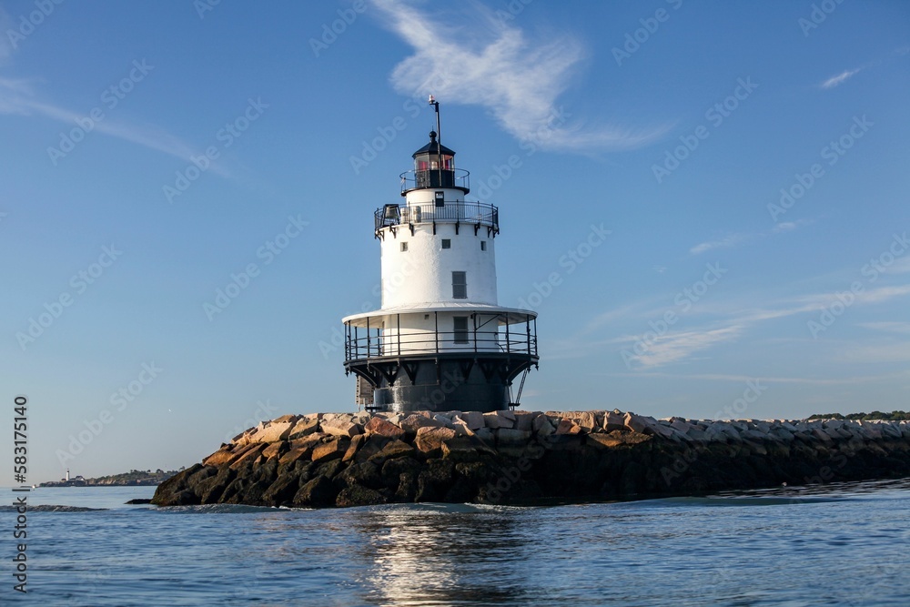 Lighthouse off the coast of Maine on rocks surrounded by seascape Lighthouse off the coast of Maine on rocks surrounded by seascape