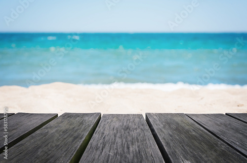 Empty wooden table with blurred beach background