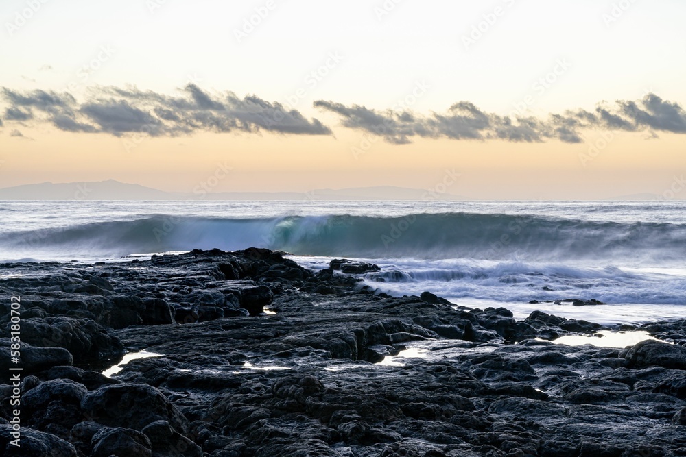 Beautiful seascape view with white and foamy waves against a scenic sunrise in Oahu, Hawaii