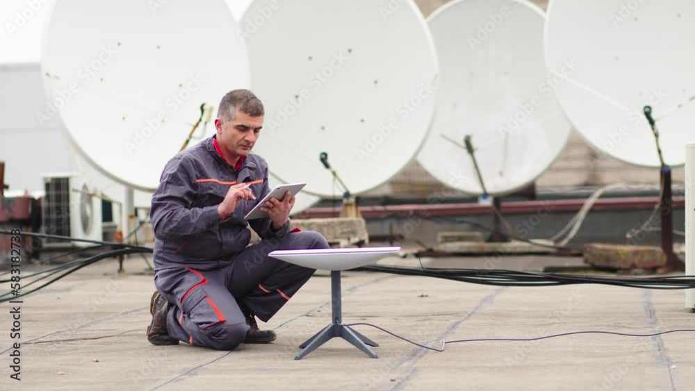 A Starlink dish is installed for a satellite signal on the roof of an office building. Engineer configuring communication with satellites A Starlink dish is installed for a satellite signal on the roof of an office building. Engineer configuring communication with satellites