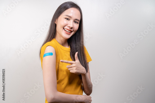Portrait of pretty  beautiful asian young  teenage attractive after getting  receive anti virus vaccine covid-19. Showing arm on white bandage isolated on white background  copy space.