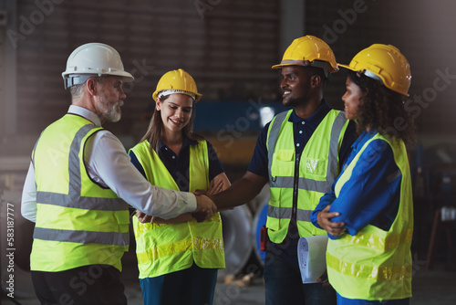 Diverse people working together with colleague in factory, Cooperation in factory with project manager and engineer hand shaking to work together on metal sheet industrial project.