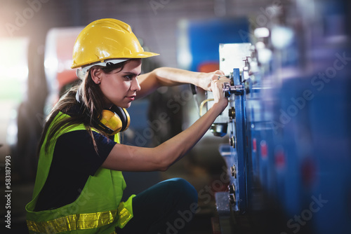 Confident caucasian engineering woman factory worker waering safety hard hat working in warehouse. photo