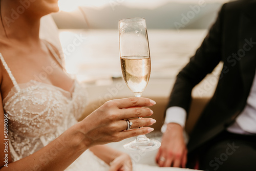 bride and groom newlyweds drinking champagne wine on boat on wedding day sunset romantic boho 