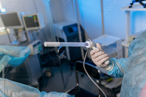 Professional surgeon proctologist before operation holding special devices for colonoscopy in the operating room in hospital. Urgent surgical concept