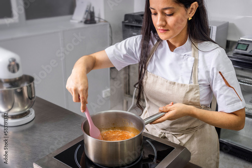 Schilderij op canvas Colombian pastry chef bakes liquid caramel for her cake