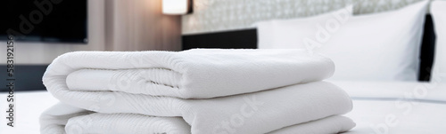 Towels on the bed in white color in the hotel room. Generative AI, © yanadjan