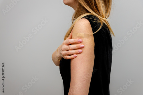 Woman shown in profile showing hand with patch. The concept of seasonal vaccination. The return of viruses. 