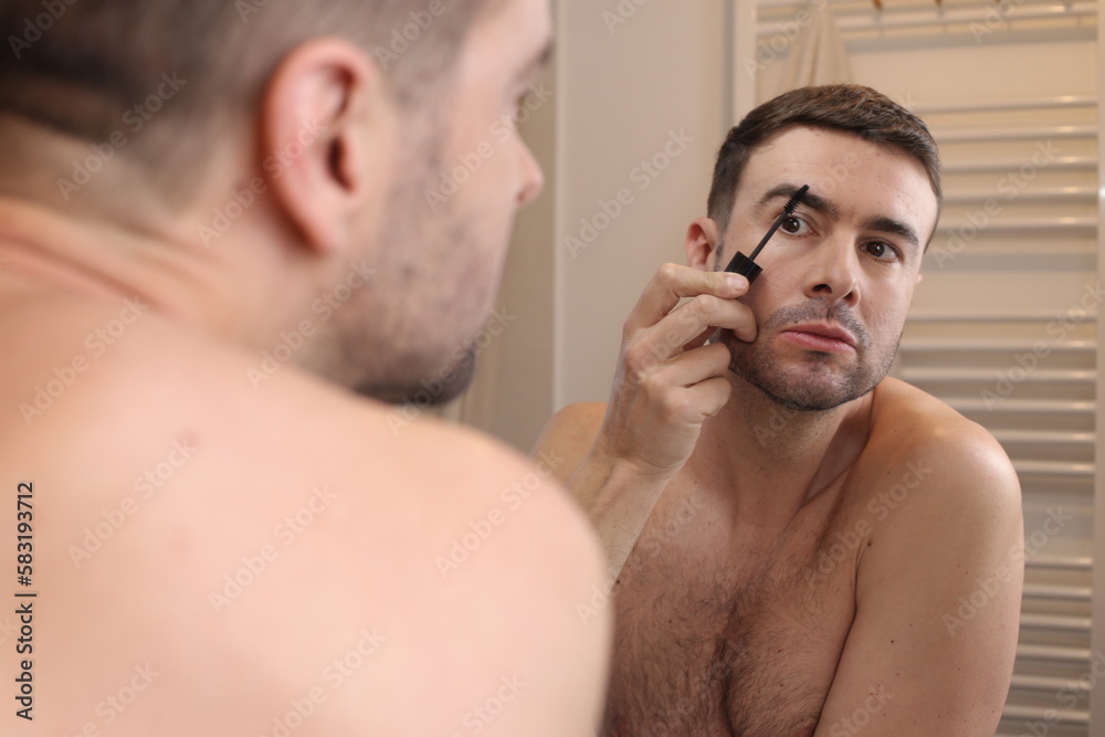Obraz premium Man combing his eyebrows in the bathroom