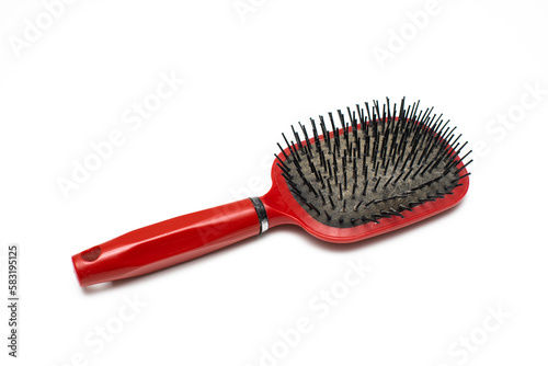 old red hairbrush with sticking out hair.