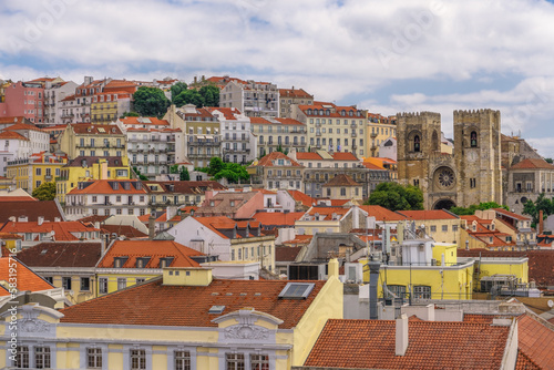 Lisbon, Portugal panoramic landscape of 12th-century Lisbon Cathedral, Se De Lisboa, surrounded by traditional low-rise red tile rooftop buildings.