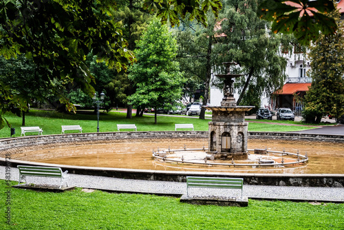 The artesia fountain in the Dimitrie Ghica park and behind it is the Caraiman hotel. Sinaia, Romania. photo