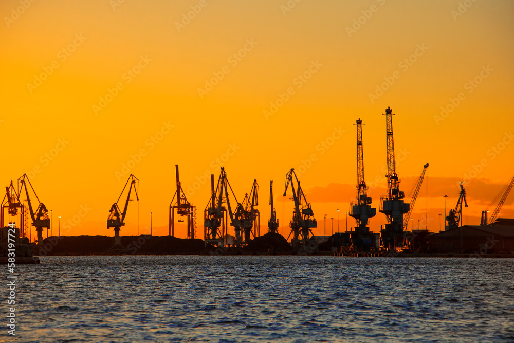 Silhouette of the sea cargo port at sunset. Travel concept