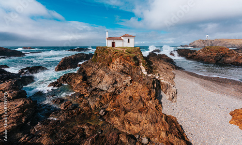 Galicia Spain. Atlantic coast rough sea. White Chapel on top of a rock. Virxe do Porto, Valdoviño photo