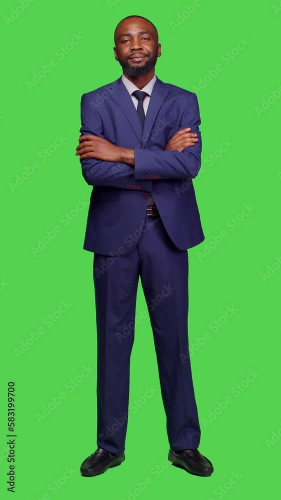 Vertical video: Front view of startup manager feeling confident on camera, wearing business suit to work on corporate job. Smiling adult entrepreneur posing over greenscreen full body background Vertical video: Front view of startup manager feeling confident on camera, wearing business suit to work on corporate job. Smiling adult entrepreneur posing over greenscreen full body background