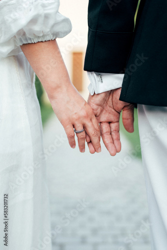 Close-up view of a married couple holding hands