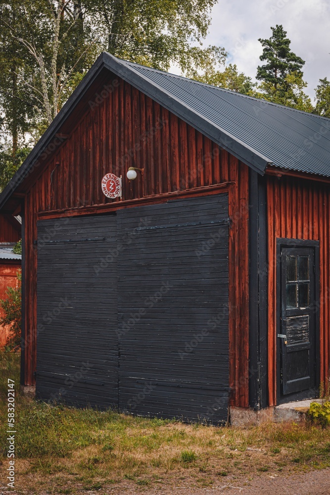 Vertical shot of a red and black wooden building in a village in Sweden Vertical shot of a red and black wooden building in a village in Sweden