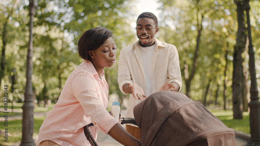 Young man arguing with wife in park, relationship stress after having a baby Young man arguing with wife in park, relationship stress after having a baby