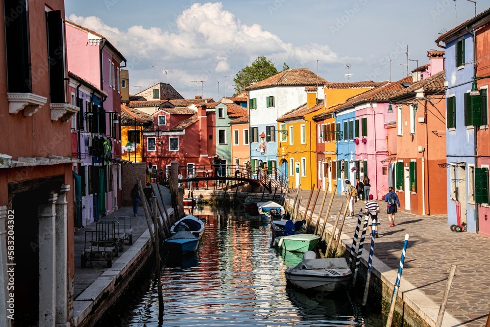 Beautiful outdoor view of boats docked on the canal and colorful buildings on the sides