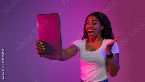Portrait Of Excited Black Woman Looking At Digital Tablet Screen