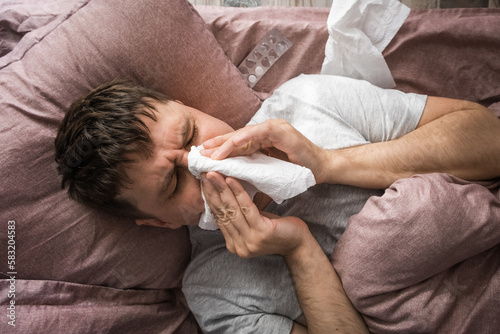 Konstfotografi Ill caucasian young man sick with flu, cold or virus blowing running nose, got f