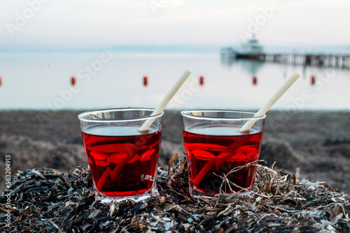 cocktail, juice in a transparent glass with a bamboo drinking tube on the seashore