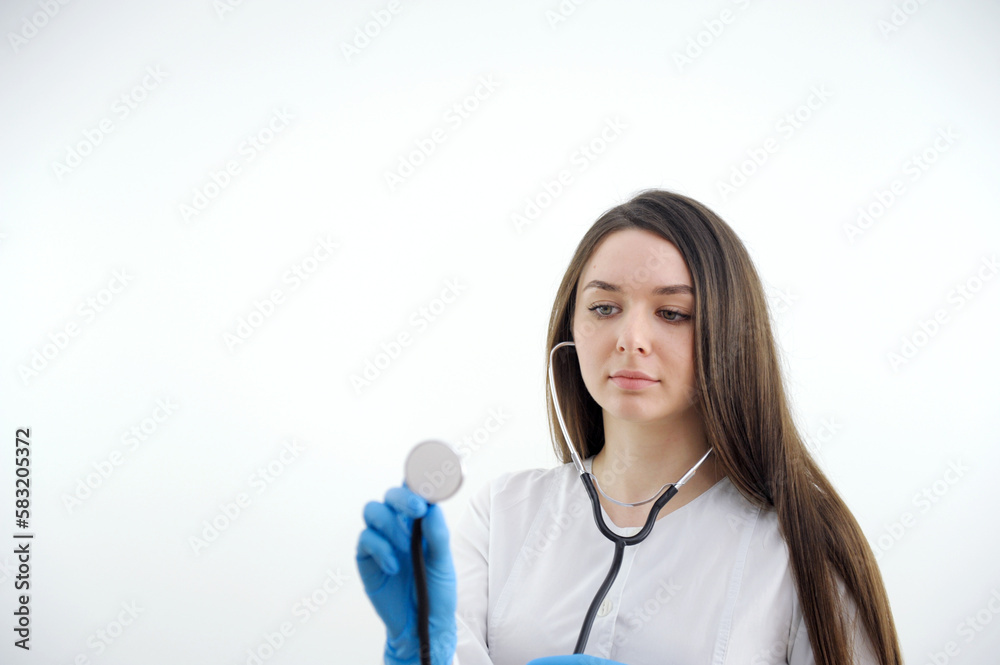 Beautiful young African American nurse or doctor with stethoscope stands, looking to the right side wearing blue scrubs and long curly hair Beautiful young African American nurse or doctor with stethoscope stands, looking to the right side wearing blue scrubs and long curly hair