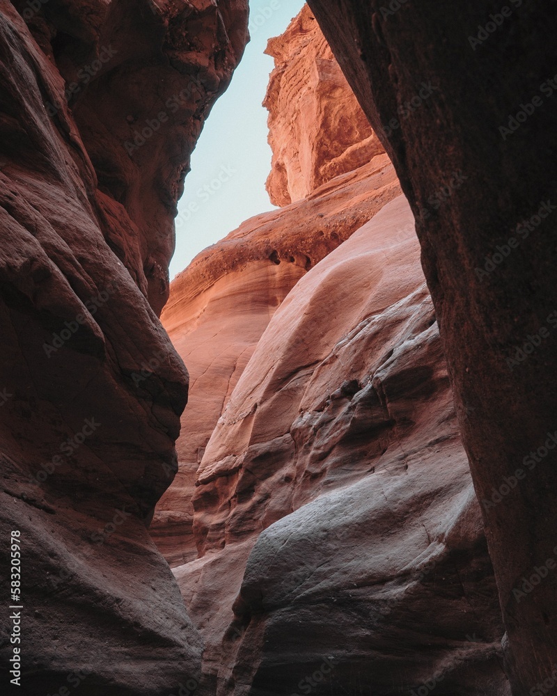 Vertical shot of red rock formations with a light in the background
