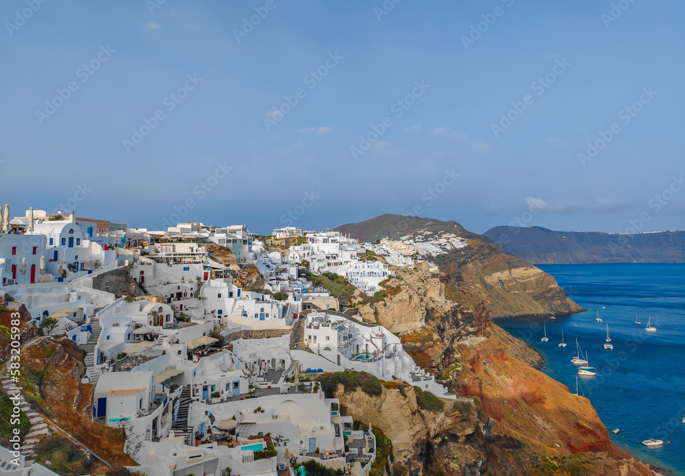 Panoramic view of Oia village on Santorini island, Greece. Town with cycladic white houses located on the cliffs of the island.