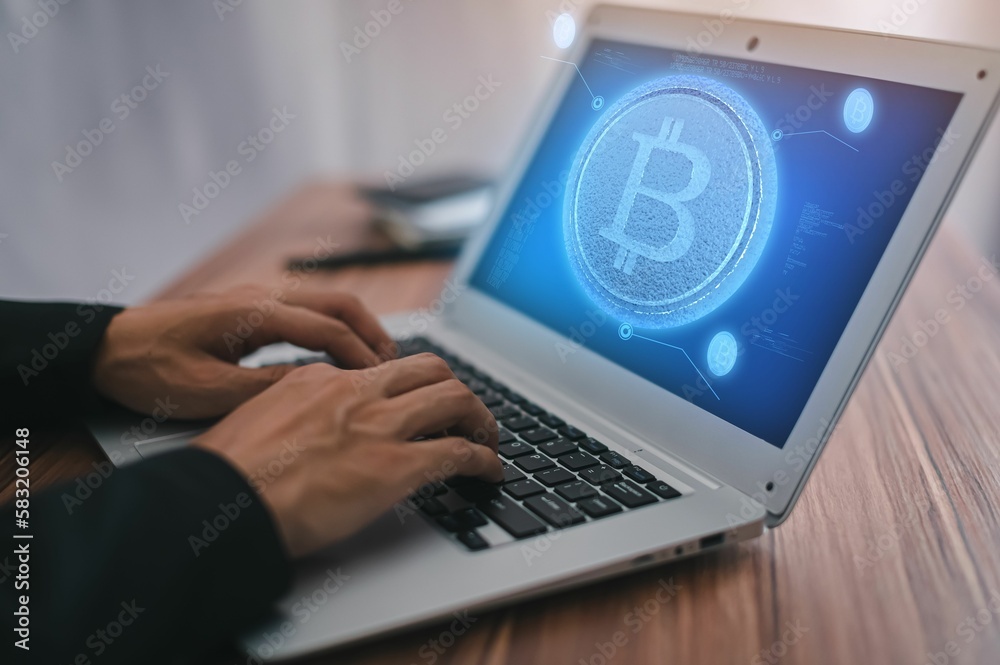 Man typing on a laptop with a bitcoin symbol on the screen, close-up Man typing on a laptop with a bitcoin symbol on the screen, close-up