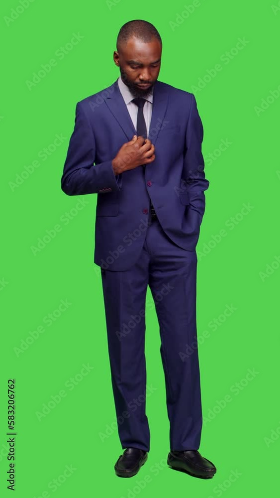 Vertical video: Front view of african american man in suit waiting for something, standing over full body greenscreen background. Male startup employee feeling impatient and pacing on camera, formal Vertical video: Front view of african american man in suit waiting for something, standing over full body greenscreen background. Male startup employee feeling impatient and pacing on camera, formal