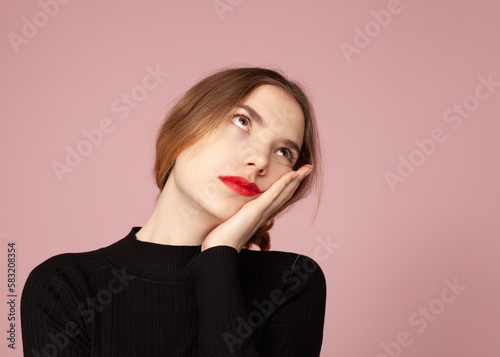 sad. upset woman on a pink background