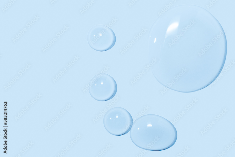 large drops of transparent Gel liquid, water on a blue background, top view, close-up large drops of transparent Gel liquid, water on a blue background, top view, close-up