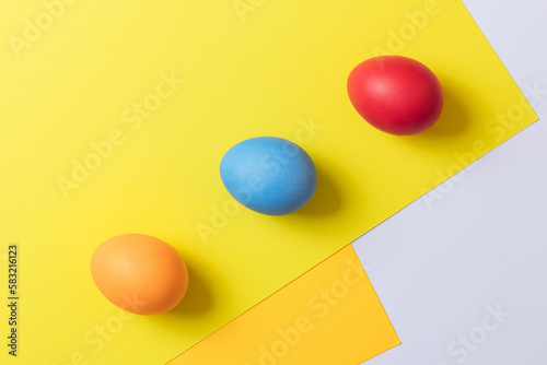 Colorful painted eggs on bright multicolor geometric background. Concept scene. Easter eggs. Selective focus. Top view.