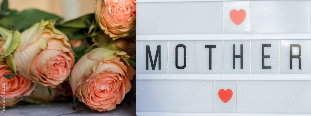 Fototapeta premium Happy Mother's Day.Lightbox with the word Happy Mother's Day next to flowers. Holiday card.