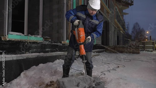 Cement split. Clip. A man in a uniform working with special equipment in winter. photo