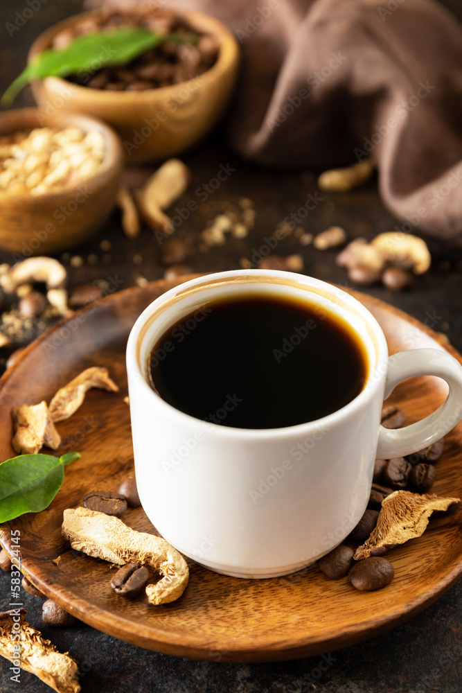 Healthy organic energizing adaptogen. Mushroom coffee in a cup and coffee beans, trendy drink on a stone background. Healthy organic energizing adaptogen. Mushroom coffee in a cup and coffee beans, trendy drink on a stone background.