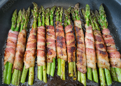 Viele Bündel grüner Spargel im Speckmantel in der Pfanne, Low Carb, Keto Ernährung