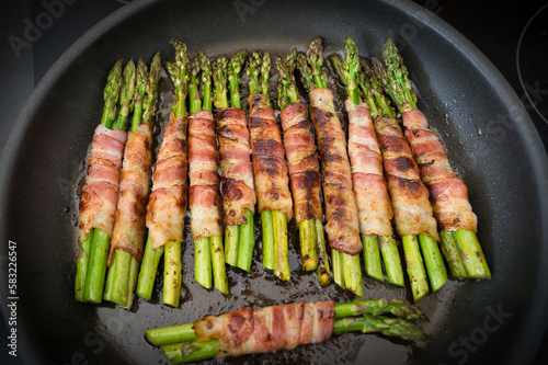 Viele Bündel grüner Spargel im Speckmantel in der Pfanne, Low Carb, Keto Ernährung