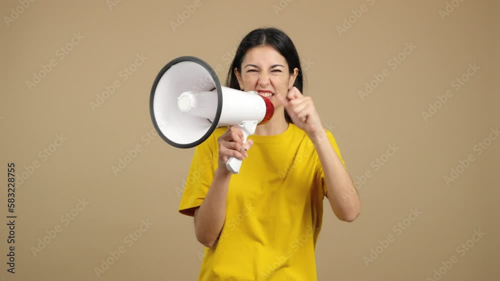 Angry caucasian woman shouting using a loudspeaker Angry caucasian woman shouting using a loudspeaker