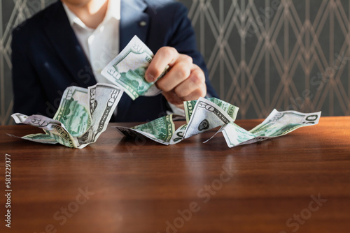 Close-up of a crumpled money, cash, banknotes and a man's hand holding it.