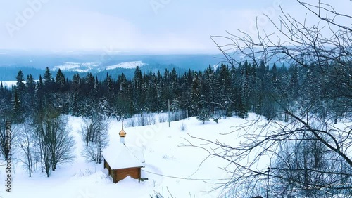 View of the chapel near the Belogorsky St. Nicholas Orthodox Missionary Monastery. Winter forest. The temple on the hill in winter. Russia, Perm Krai, Belaya Gora. 4K photo