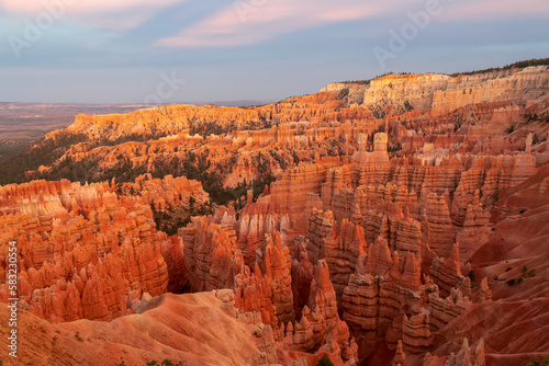 Aerial sunset view of massive hoodoo sandstone rock formation boat mesa in Bryce Canyon National Park, Utah, USA. Last sun rays touching on natural unique amphitheatre sculpted from red rock. Twilight © Chris